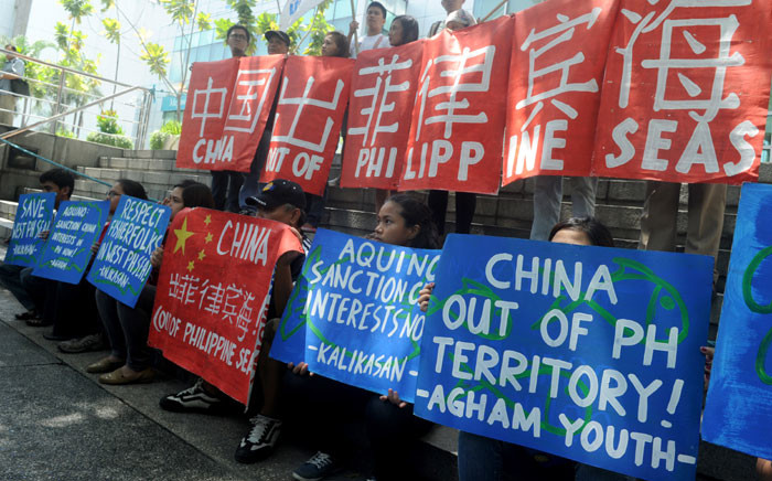 FILE: Filipino environmental activists display placards during a rally outside China's consular office in Manila on 11 May 2015, against China's reclamation and construction activities on islands and reefs in the Spratly Group of the South China Sea that are also claimed by the Philippines. Picture: AFP/Jay Directo.