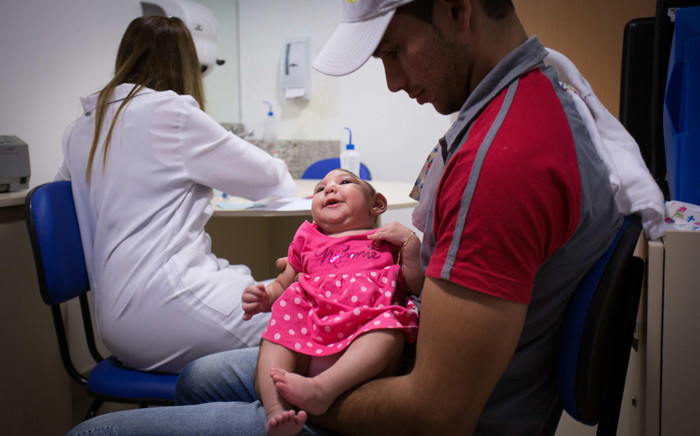 Ana Beatriz is held by her father Alipio Martin during a medical appointment at the Altino Ventura Foundation in Recife, Brazil, on 29 January 2016. In Brazil, authorities are trying to shed light on the link between Zika virus related to 4,000 babies born with microcephaly. Picture: EPA/Percio Campos.