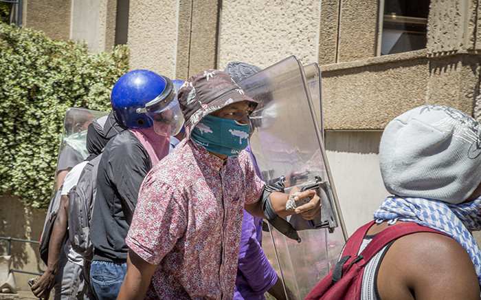 FILE: Masked #FeesMustFall supporters carry police shields and rocks during protests over tertiary education fees at Wits University's main campus on 11 October 2016. Picture: Reinart Toerien/EWN.