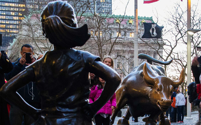 'The Fearless Girl' statue facing the iconic Wall Street charging bull statue as part of a campaign to push companies to add women on their boards on 8 March 2017 in Lower Manhattan, New York. Picture: AFP.