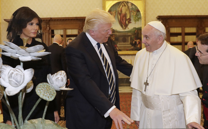Pope Francis (R) exchanges gifts with US President Donald Trump (C) and US First Lady Melania Trump during a private audience at the Vatican on 24 May 2017. Picture: AFP