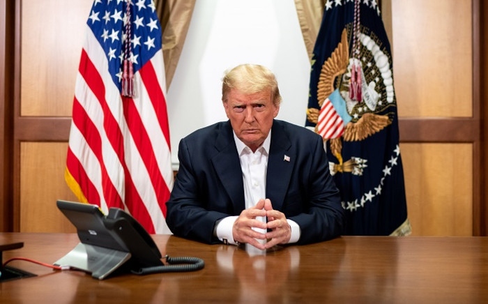 This handout photo released by the White House shows US President Donald Trump and his chief of staff (not pictured) participating in a phone call with the US vice president, secretary of state and chairman of the joint chiefs of staff on 4 October 2020, in his conference room at Walter Reed National Military Medical Center in Bethesda, Maryland. Picture: AFP.