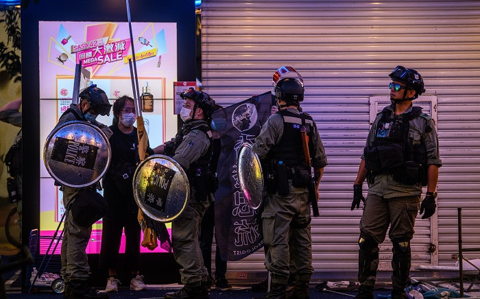 FILE: Police detain a woman (2nd L) as pro-democracy protesters gather in the Causeway Bay district of Hong Kong on 12 June 2020. Thousands of Hong Kongers sang a protest anthem and chanted slogans across the city on 12 June as they marked the one-year anniversary of major clashes between police and pro-democracy demonstrators. Picture: AFP.




