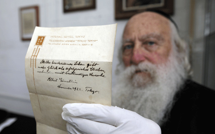 FILE: An Ultra-Orthodox Jewish man displaying one of two notes written by Albert Einstein in 1922. Picture: AFP.