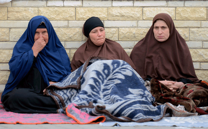 Relatives of the victims of the bomb and gun assault on the North Sinai Rawda mosque sit outside the Suez Canal University hospital in the eastern port city of Ismailia on 25 November 2017, where they were taken to receive treatment following the deadly attack the day before. Picture: AFP.