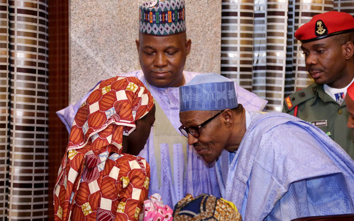 Nigerian President Mohammadu Buhari speaks with Chibok schoolgirl Amina Ali carrying her four-month-old baby as Borno state governor Kashim Shettima (C) looks on at her arrival at the presidency in Abuja, on 19 May 2016. Picture: AFP.