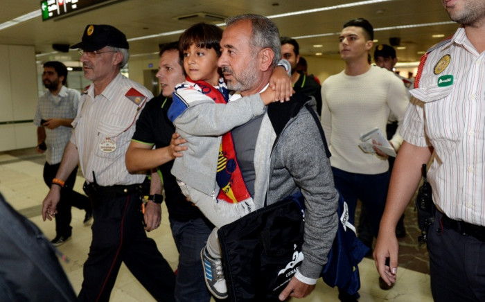Osama Abdul Mohsen (centre right), the Syrian refugee who made world headlines when a Hungarian journalist tripped him over as he fled, with his son Zaid in the corridors of Sants train station in Barcelona prior to leaving for Madrid on 16 September 2015. Picture: AFP.