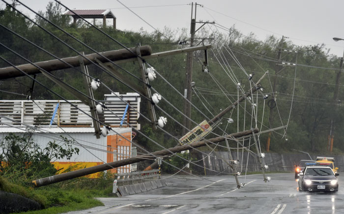 ars drive past collapsed power lines, that partially block the road, as super typhoon Meranti skirts Pingtung county in southern Taiwan on 14 September 2016. Picture: AFP."