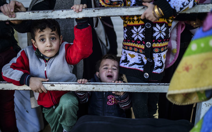 Syrian families line-up waiting to go back to Syria, on February 8, 2016 at the Turkish Oncupinar border gate near Kilis, southern-central Turkey. Thousands of Syrians were braving cold and rain at the Turkish border after fleeing a Russian-backed regime offensive on Aleppo that threatens a fresh humanitarian disaster in the country's second city. Around 40,000 civilians have fled their homes over the regime offensive, according to the Syrian Observatory for Human Rights monitor.Picture: AFP