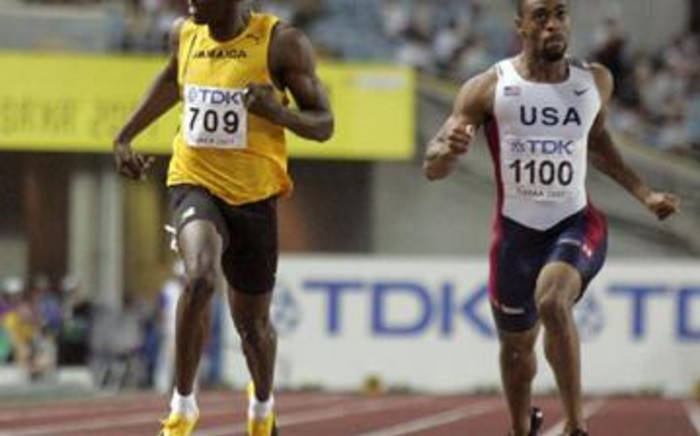 Fast feet: Usain Bolt (left) and Tyson Gay crash through the finish line at the 2007 World Championships. Picture: Gallo Images/AFP