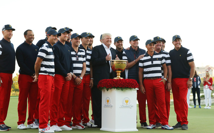 FILE: US President Donald Trump poses with the US Team and the trophy after they defeated the International Team 19 to 11 in the Presidents Cup at Liberty National Golf Club on 1 October, 2017 in Jersey City, New Jersey. Picture: AFP
