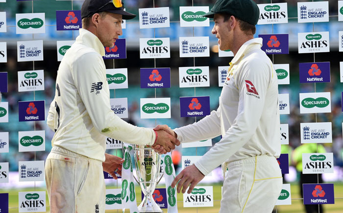 FILE: England's captain Joe Root (L) and Australia's captain Tim Paine shake hands alongside the Ashes trophy during the presentation ceremony on the fourth day of the fifth Ashes cricket Test match between England and Australia at The Oval in London on 15 September 2019. England won the fifth test by 135 runs and drew the series but Australia keeps The Ashes trophy. Picture: AFP