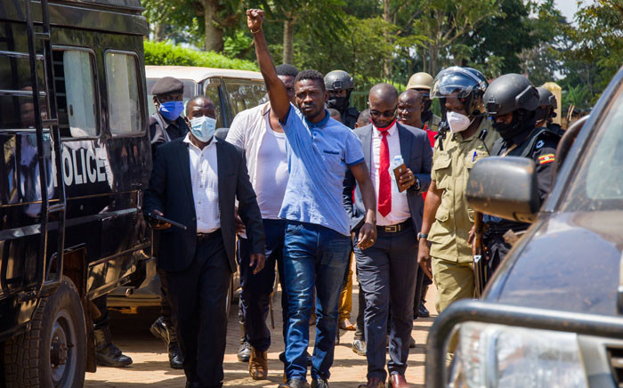 FILE: Ugandan musician turned politician Robert Kyagulanyi (C), also known as Bobi Wine, raises his arm as he walks to the court in Inganga, on November 19, 2020. Picture: AFP.