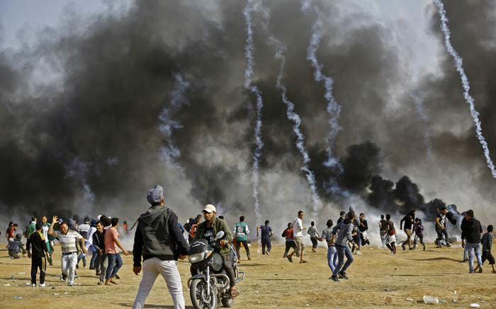 Palestinian demonstrators run to take cover from tear gas as they protest on the Israel-Gaza border, east of the northern town of Jabalia, on 27 April 2018. Picture: AFP.