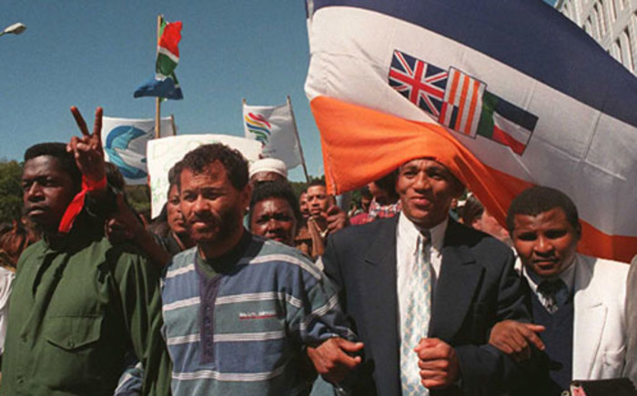 Miles Bhudu (L),head of the South African Prisoners Organisation for Human Rights, Rashied Staggie (2ndL), leader of the Hard Living Kids gang, Pastor Alben Martins(2ndR), a reformed gangster and a church associate walk underneath the South African flag during a march to Parliament in Cape Town 22 September, 1996. Picture: AFP