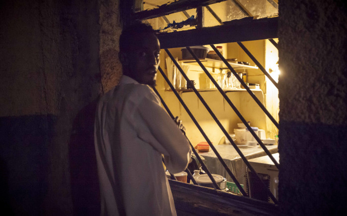 A foreign national stands by the open window to the makeshift kitchen at a sanctuary in Mayfair, Johannesburg, after he fled violence against foreign nationals owning spaza shops in Soweto. Picture: Thomas Holder/EWN