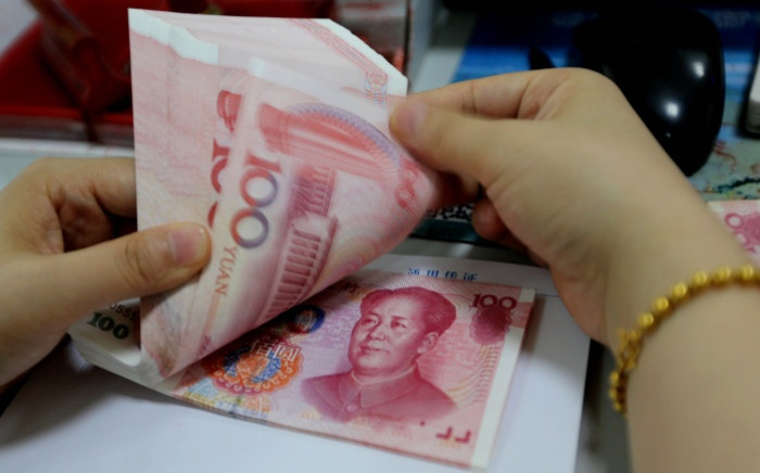 FILE: A teller counts yuan banknotes in a bank in Lianyungang, east China’s Jiangsu province. Picture: AFP.