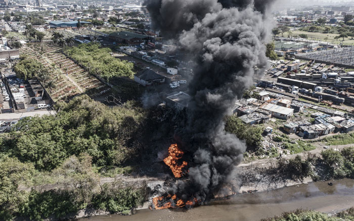 Flames and smoke billow from the site of a petrol tanker that caught fire in Clairwood Industrial Park and ignited a secondary fire in the Transnet Pipe, in Durban, on 31 October 2021. Picture: MARCO LONGARI/AFP