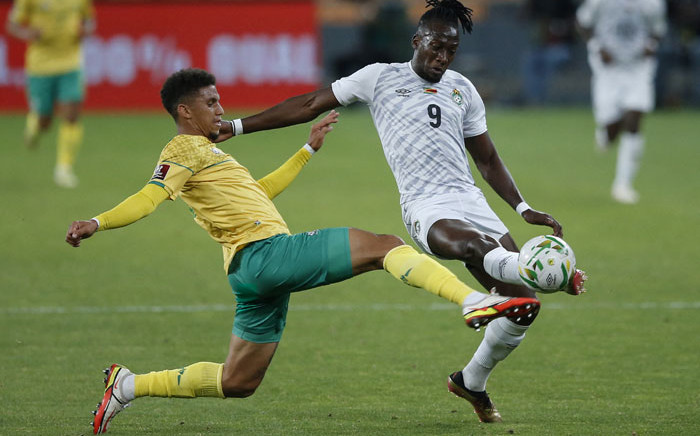 South Africa's Rushine de Reuck (L) tackles Zimbabwe's David Moyo (R) during the Fifa 2022 World Cup qualifying round Group G football match between South Africa and Zimbabwe at the FNB Stadium in Johannesburg on 11 November 2021. Picture: PHILL MAGAKOE/AFP