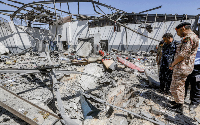 Military officers of the Libyan Government of National Accord (GNA)inspect damage and debris at a migrant detention centre used by the GNA in the capital Tripoli's southern suburb of Tajoura on July 3, 2019, following an air strike on a nearby building that left dozens killed the previous night. Picture: AFP.
