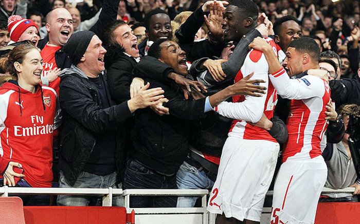 Arsenal fans celebrate with Yaya Sanogo and Alex Oxlade-Chamberlain after reaching the last 16 of the Uefa Champions League on 26 November 2014. Picture: Arsenal Facebook page.