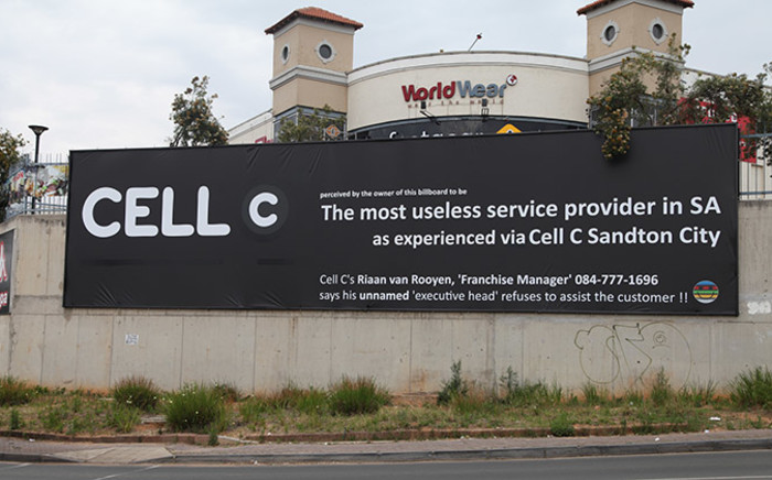 The banner erected by a disgruntled Cell C customer outside the World Wear shopping centre on Beyers Naude drive in Fairland, Johannesburg, was altered after the cellphone company sought legal advice on the matter. Picture: Reinart Toerien/EWN.