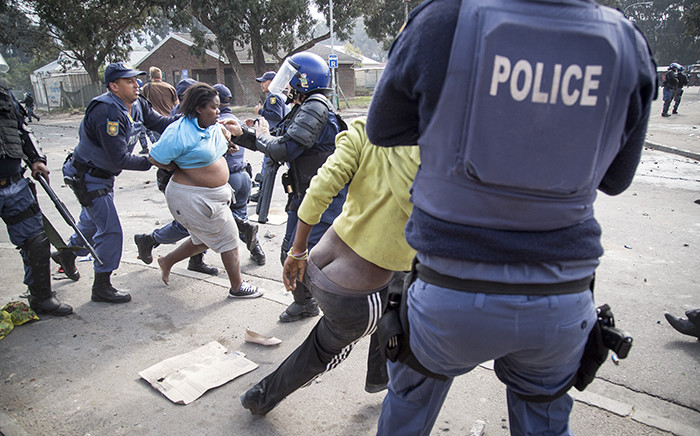 FILE: After issuing a warning order for a crowd of roughly 400 people in Masiphumelele township in Cape Town, police began arresting protesting residents. Some fell over in the scramble, their clothing coming off in the chaos. Picture: Thomas Holder/EWN.