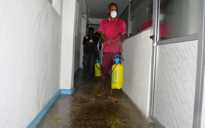An employee disinfects an office in Monrovia where offices were closed for disinfection against the epidemic of the haemorrhagic fever Ebola on 1 August 2014. Picture: AFP.