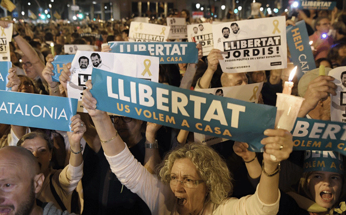 People hold placards reading 'Freedom' during candle-lit demonstration in Barcelona against the arrest of two Catalan separatist leaders on 17 October 2017. Picture: AFP