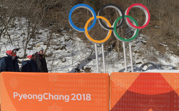 Volunteers walk past the Olympics Rings at the Jeongseon Alpine Centre ahead of the PyeongChang 2018 Winter Olympic Games in Jeongseon on 7 February 2018. Picture: AFP.