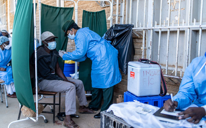 A member of the military administers the SinoVac vaccine to a citizen at a mobile clinic in Emganwini township, Bulawayo, Zimbabwe, on 3 August 2021. Picture: Zinyange Auntony/AFP