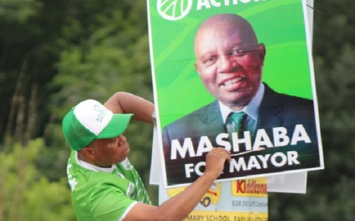ActionSA leader Herman Mashaba puts up a campaign poster of himself. Picture: ActionSA/Twitter