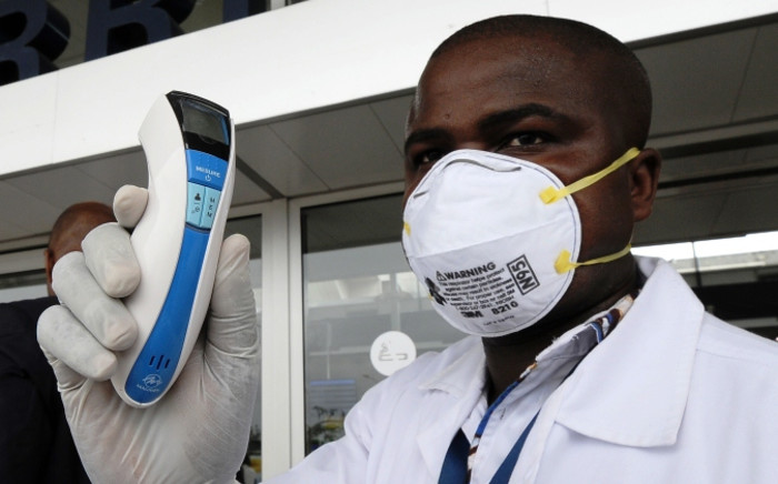 FILE: An agent of the national public health institute poses with a thermometer at the airport, in Abidjan on 12 August, 2014. Picture: AFP. 