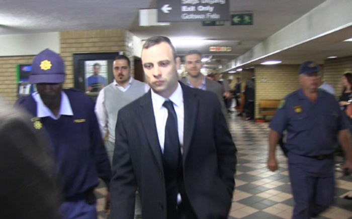 Oscar Pistorius is escorted into the High Court in Pretoria ahead of his murder trial on 14 April 2014. Picture: Reinart Toerien/EWN.