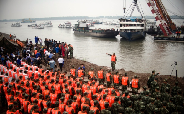 FILE: Chinese soldiers and rescue workers pay their respect to the victims during a memorial service in front of the raised Chinese cruise ship, in Jianli on 7 June, 2015. Picture: AFP.