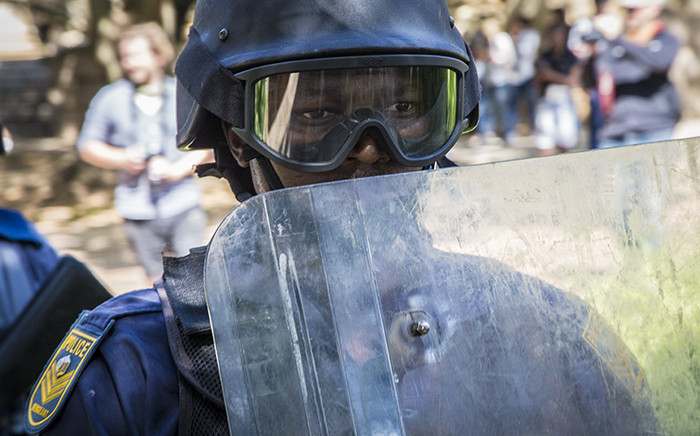 FILE: A Saps member walks close to his shield during sporadic running battles between police and #FeesMustFall supporters at Wits University on 11 October 2016. Picture: Reinart Toerien/EWN