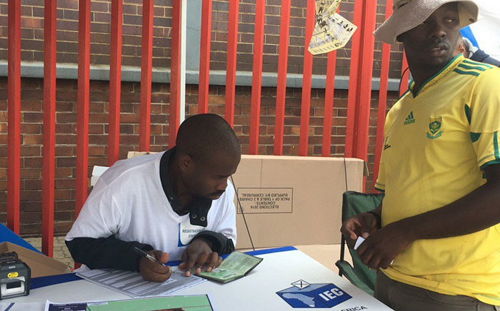 An IEC official assists a Denver resident during voter registration weekend. Picture: Govan Whittles/EWN.