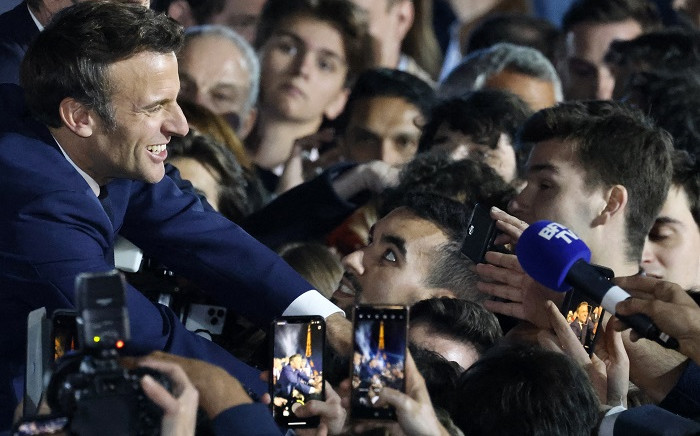 French President and La Republique en Marche (LREM) party candidate for re-election Emmanuel Macron (L) greets supporters after his victory in France's presidential election, at the Champ de Mars in Paris, on April 24, 2022. Picture: Ludovic Marin / AFP