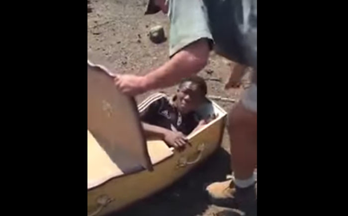 A screengrab of Rethabile Mlotshwa being forced into a coffin.