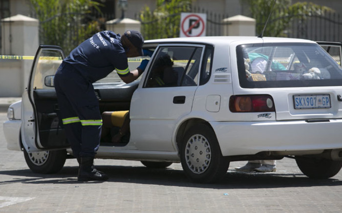 Forensic experts inspect the scene where a woman was shot dead by straying bullet during a taxi gun battle in Midrand on 9 October 2014. Picture: Christa Eybers/EWN.