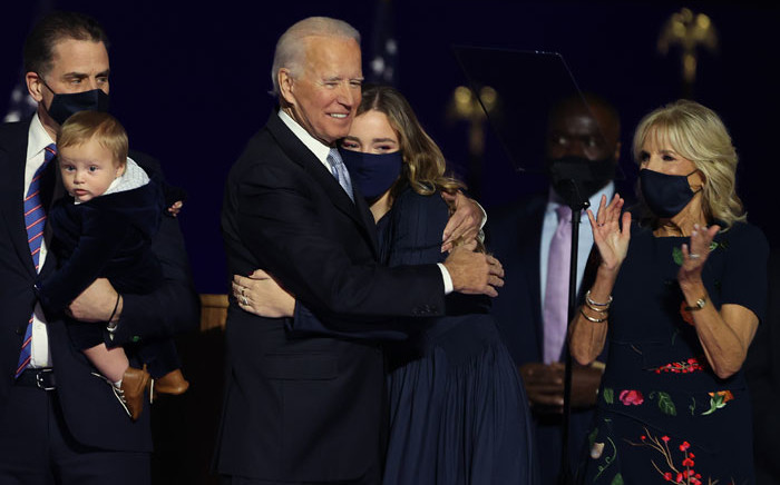President-elect Joe Biden hugs his grandchild on stage after Biden's address to the nation from the Chase Center 7 November 2020 in Wilmington, Delaware. Picture: AFP