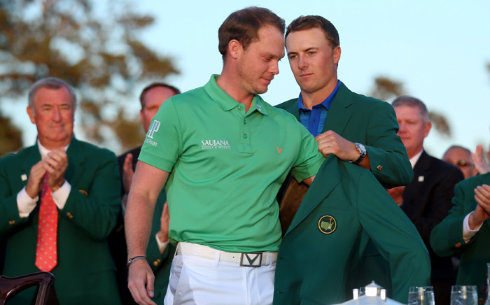 FILE. Jordan Spieth of the United States presents Danny Willett of England with the green jacket after Willett won the 2016 Masters Tournament at Augusta National Golf Club on 10 April, 2016 in Augusta, Georgia. Picture: AFP.