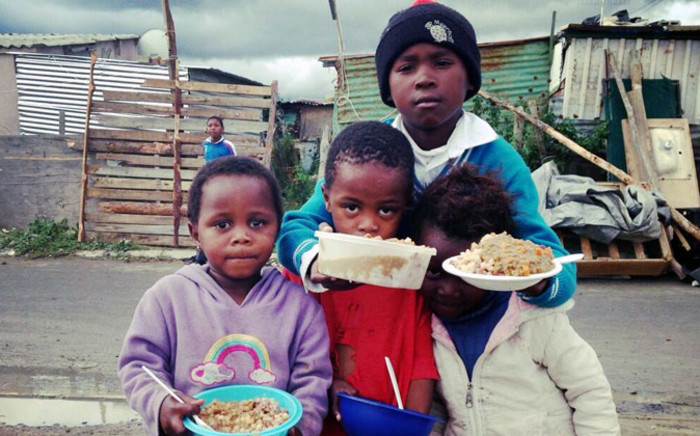 Children in Nomzamo are being given food as police continued their operation to evicted hundreds of families in the area on 4 June 2014. Picture: Carmel Loggenberg/EWN.