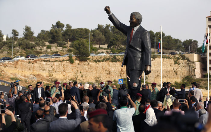 Palestinian and South African officials stand next to a giant statue of Nelson Mandela during its inauguration ceremony in the West Bank city of Ramallah on 26 April 2016. Picture: Abbas Momani/AFP.
