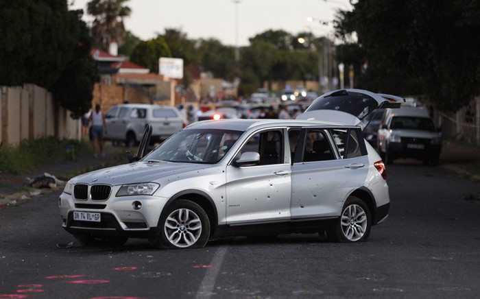 A bullet-riddled vehicle is stationed in the middle of the street, part of the crime scene after a botched cash-in-transit attack in Rosettenville, on the outskirts of Johannesburg on 21 February 2022, resulting in two South African police officers being airlifted with chest wounds. Picture: GUILLEM SARTORIO/AFP