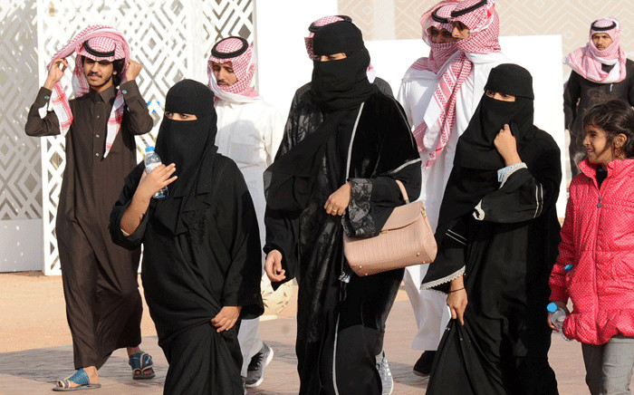 FILE: A picture taken on 19 January 2018 shows Saudi women and men walking during the King Abdulaziz Camel Festival in Ruma. Picture: AFP.