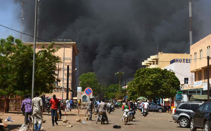 People watch as black smoke rises as the capital of Burkina Faso came under multiple attacks on 2 March 2018, targeting the French embassy, the French cultural centre and the country's military headquarters. Picture: AFP