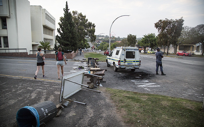 Public Order Police patrol an entry point to the Rhodes University campus that was barricaded earlier by students protesting fee hikes in the New Year. Picture: Thomas Holder/EWN.