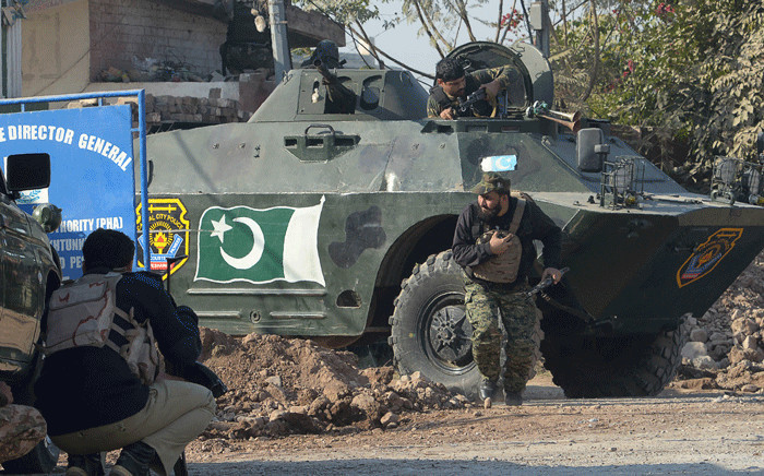 Pakistani security personnel take position outside an Agriculture Training Institute after an attack by Taliban militants in Peshawar on 1 December 2017. Picture: AFP
