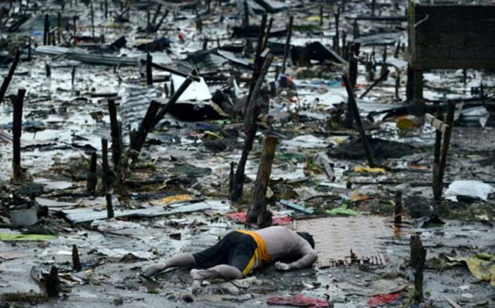 The body of a dead man is seen at the bay of Tacloban on 10 November 2013 amid the wreckage caused by Typhoon Haiyan in the Philippines. Picture: Noel Celis/AFP.